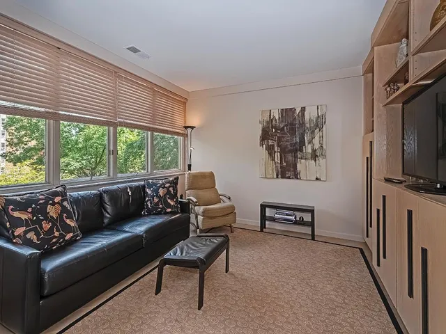 a living room with furniture a flat screen tv and a window