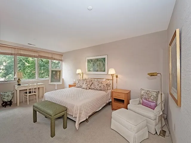 a bedroom with a bed and a refrigerator