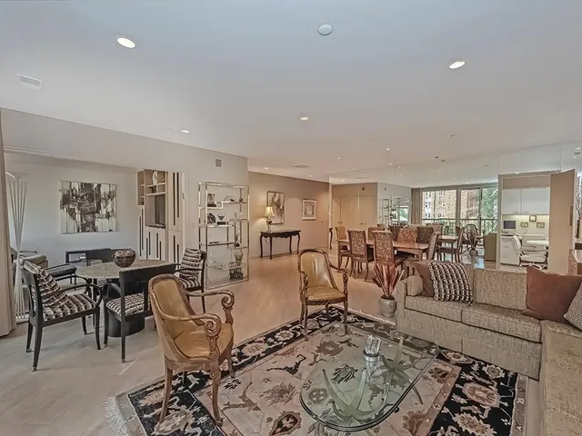 a living room with lots of furniture a rug and white walls