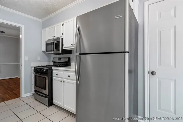 a kitchen with stainless steel appliances a refrigerator a stove a microwave and cabinets