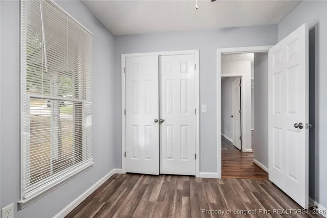 a view of hallway with windows and wooden floor
