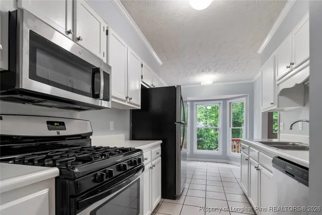 a kitchen with stainless steel appliances a stove a microwave sink and refrigerator