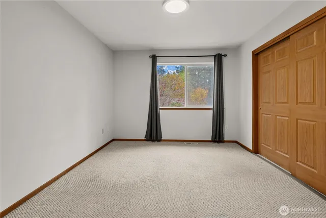 an empty room with windows and closet