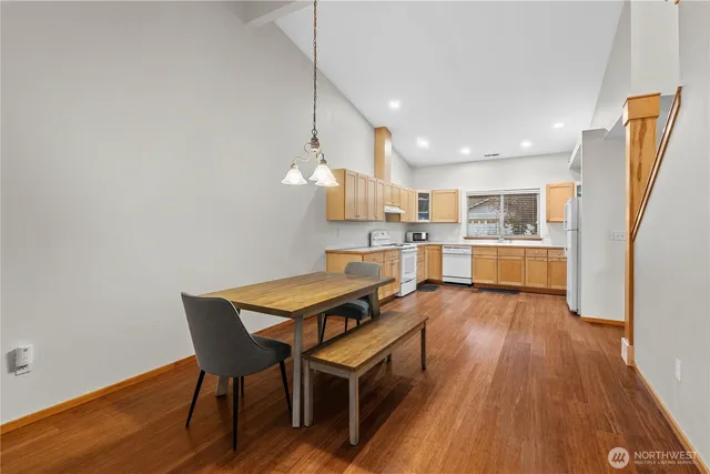 a kitchen with stainless steel appliances wooden floor and a refrigerator