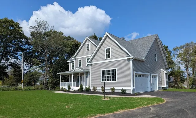 a front view of a house with a yard and trees
