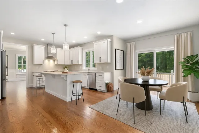 a kitchen with a table chairs refrigerator and cabinets