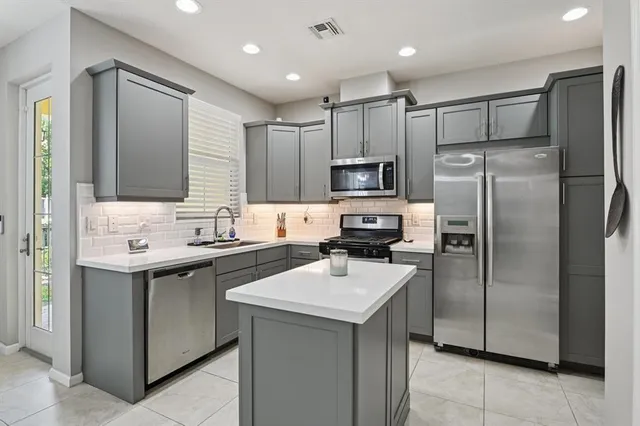 a kitchen with a sink appliances and cabinets
