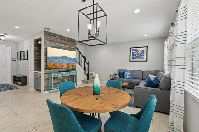 a living room with furniture a flat screen tv and a table