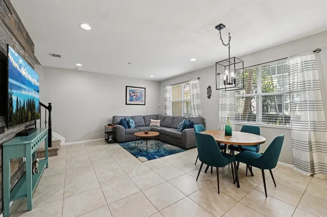 a living room with furniture a flat screen tv and a window