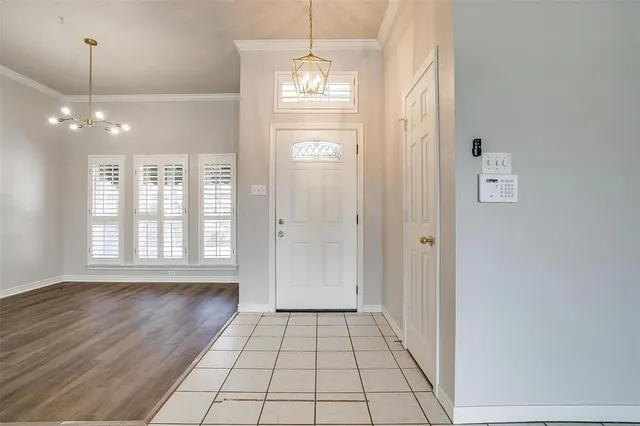 a view of a hallway with windows and chandelier
