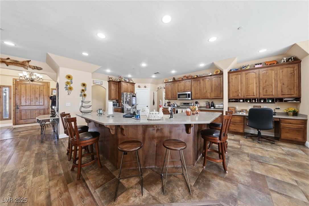 1285 Embry Avenue Moapa, NV 89025 - Photo 35 of 98 Kitchen with brown cabinets, a large island, a kitchen breakfast bar, stainless steel appliances, and recessed lighting