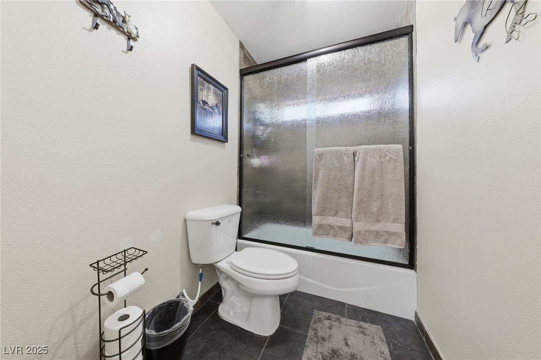 1285 Embry Avenue Moapa, NV 89025 - Photo 41 of 98 Full bath with enclosed tub / shower combo and dark tile patterned floors