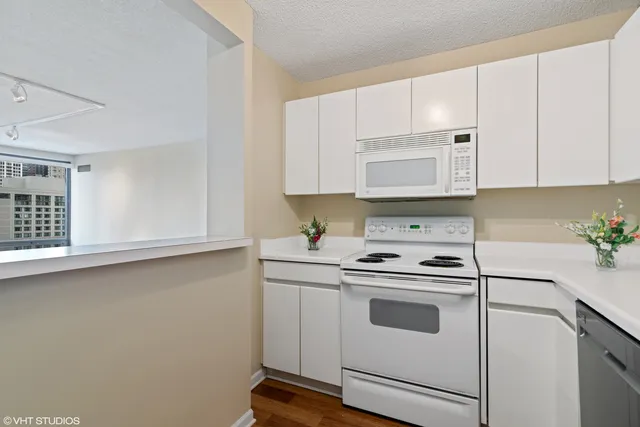 a kitchen with white cabinets and white appliances