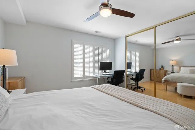 a bedroom with a bed couches and a flat tv screen