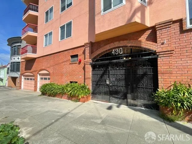 a front view of a building with a garden and entryway
