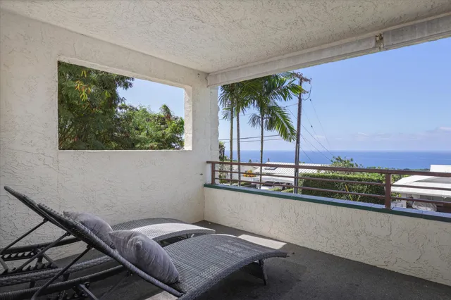 a living room with a couch and a potted plant