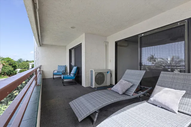 a balcony with wooden benches and a couch
