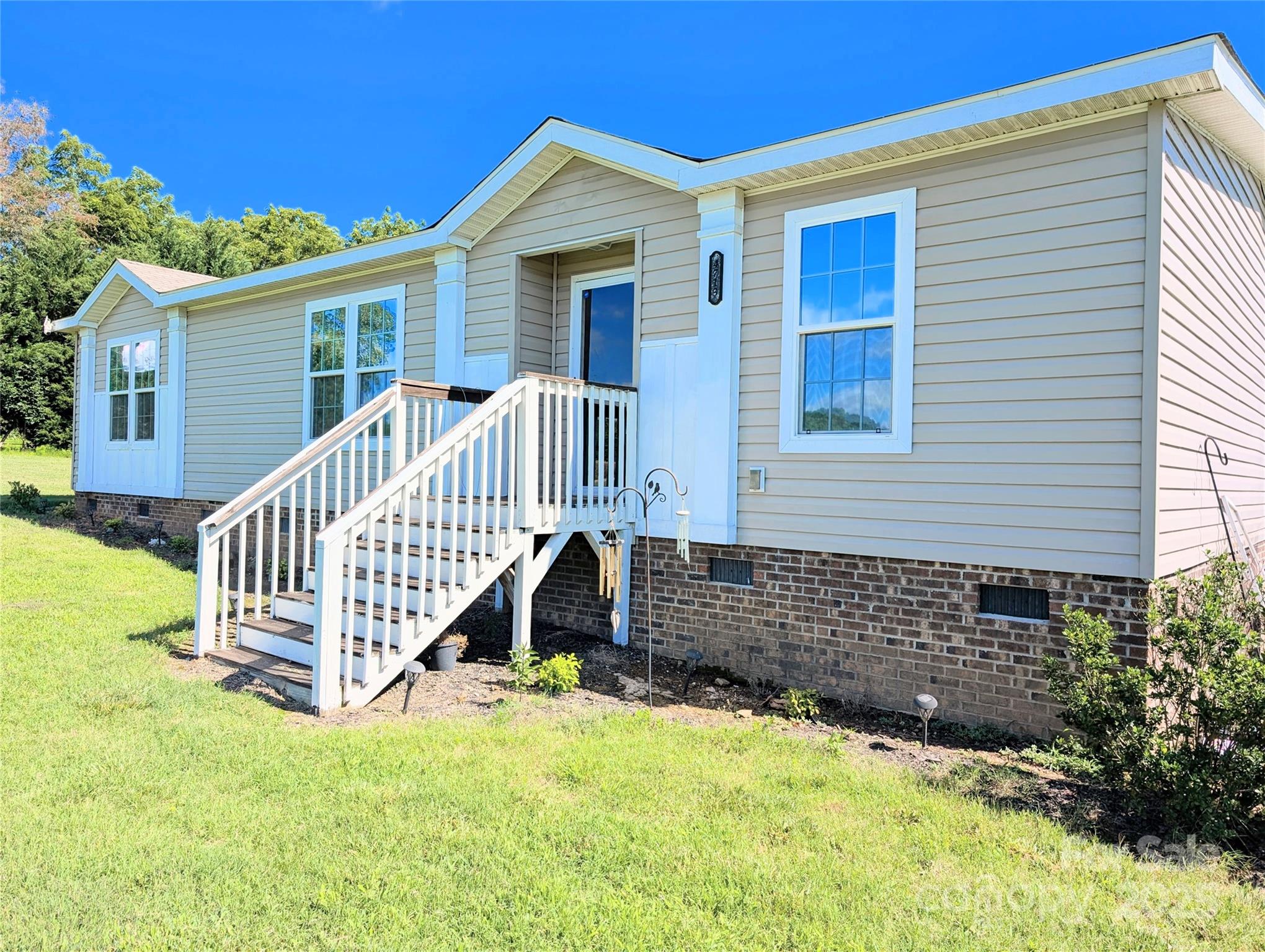 a view of a house with wooden deck and a yard