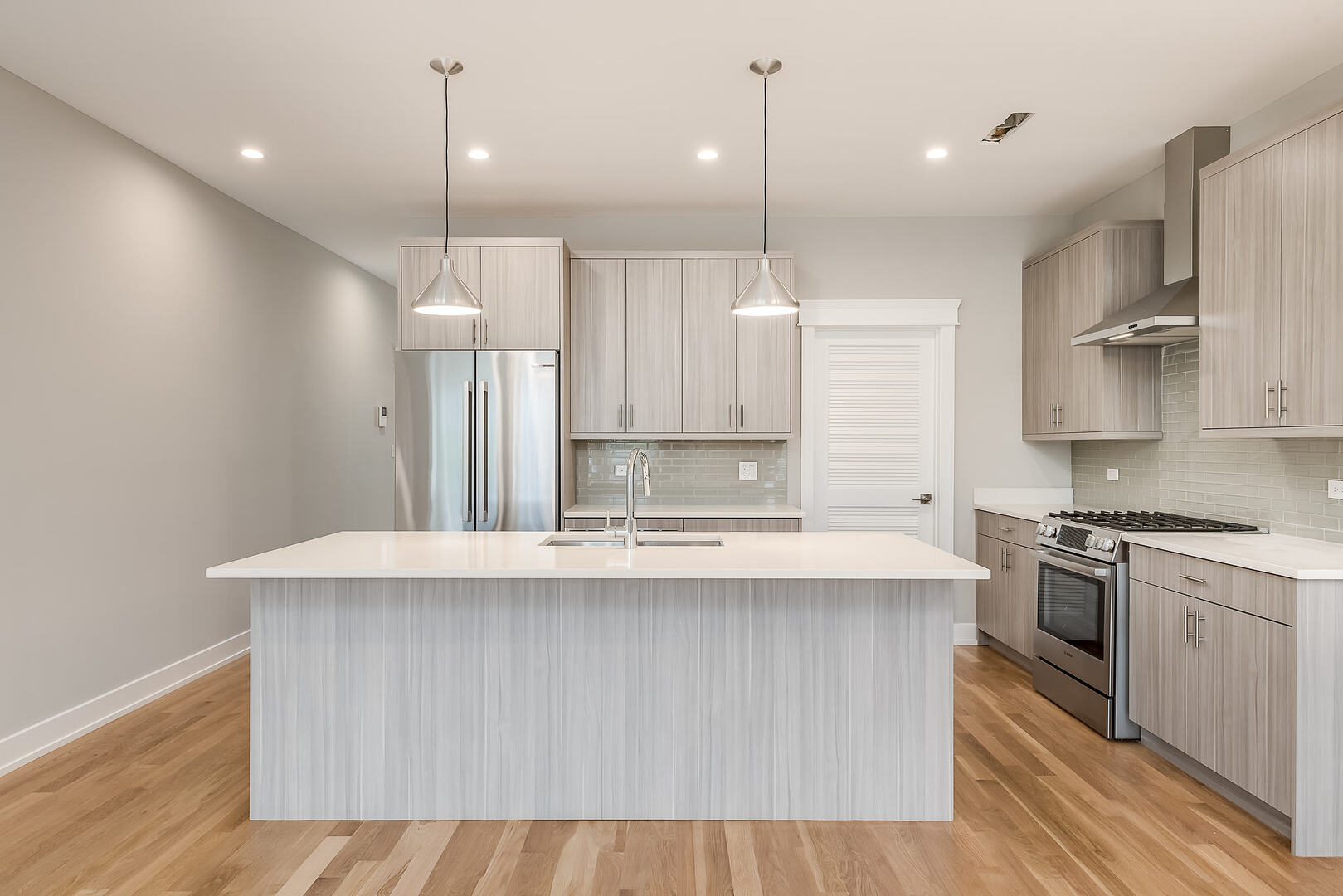 2145 South Halsted Street, Unit 4S Chicago, IL 60608 - Photo 7 of 29 a large kitchen with stainless steel appliances kitchen island a large island in the center