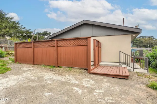 a view of a house with a wooden fence