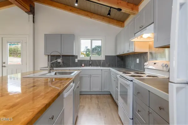 a kitchen with a sink stove top oven and refrigerator
