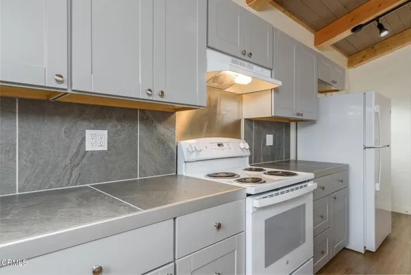 a kitchen with granite countertop a sink stove and refrigerator