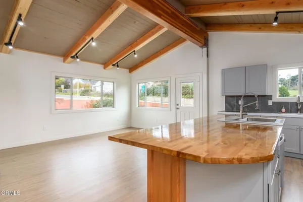 a view of kitchen with kitchen island a sink appliances and a counter top