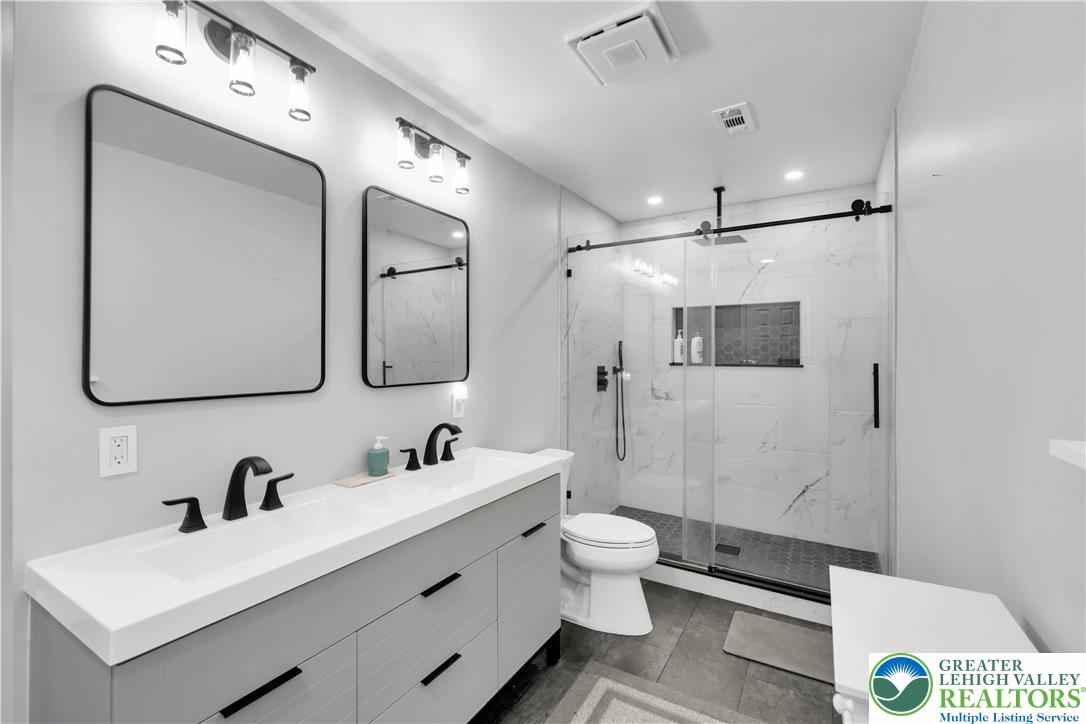 2011 Greenwood Road Allentown, PA 18103 - Photo 35 of 52 A well-appointed bathroom features a spacious dual-sink vanity and an elegant glass-enclosed shower.