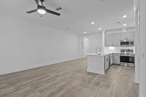 a view of wooden floor and a chandelier fan in a room