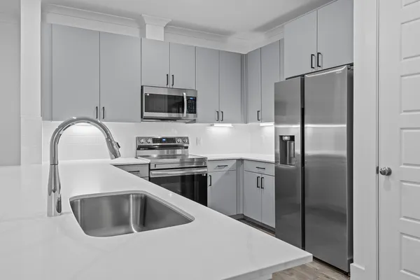 a kitchen with kitchen island sink stove and cabinets