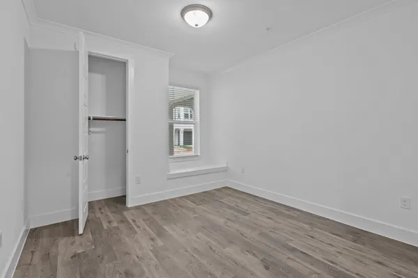 a view of a room that has wooden floor and windows in it