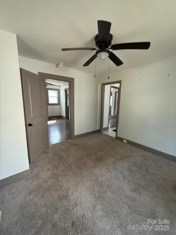en empty room with windows and ceiling fan