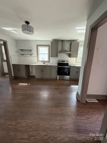 a large kitchen with a lot of counter space and wooden floor