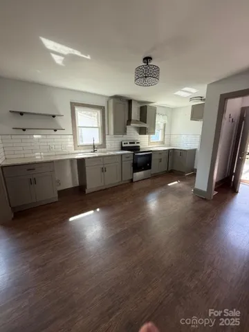 a large kitchen with granite countertop a large counter top stainless steel appliances and wooden floor