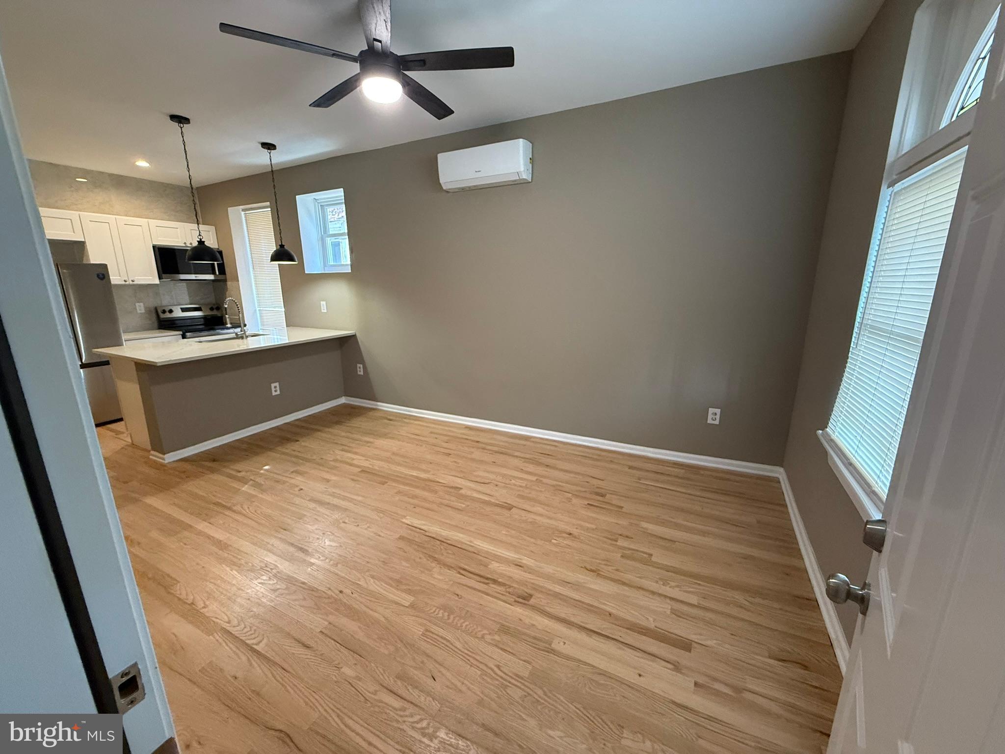 5618 Cedar Avenue, Unit 1 Philadelphia, PA 19143 - Photo 4 of 20 a view of kitchen and empty room with wooden floor
