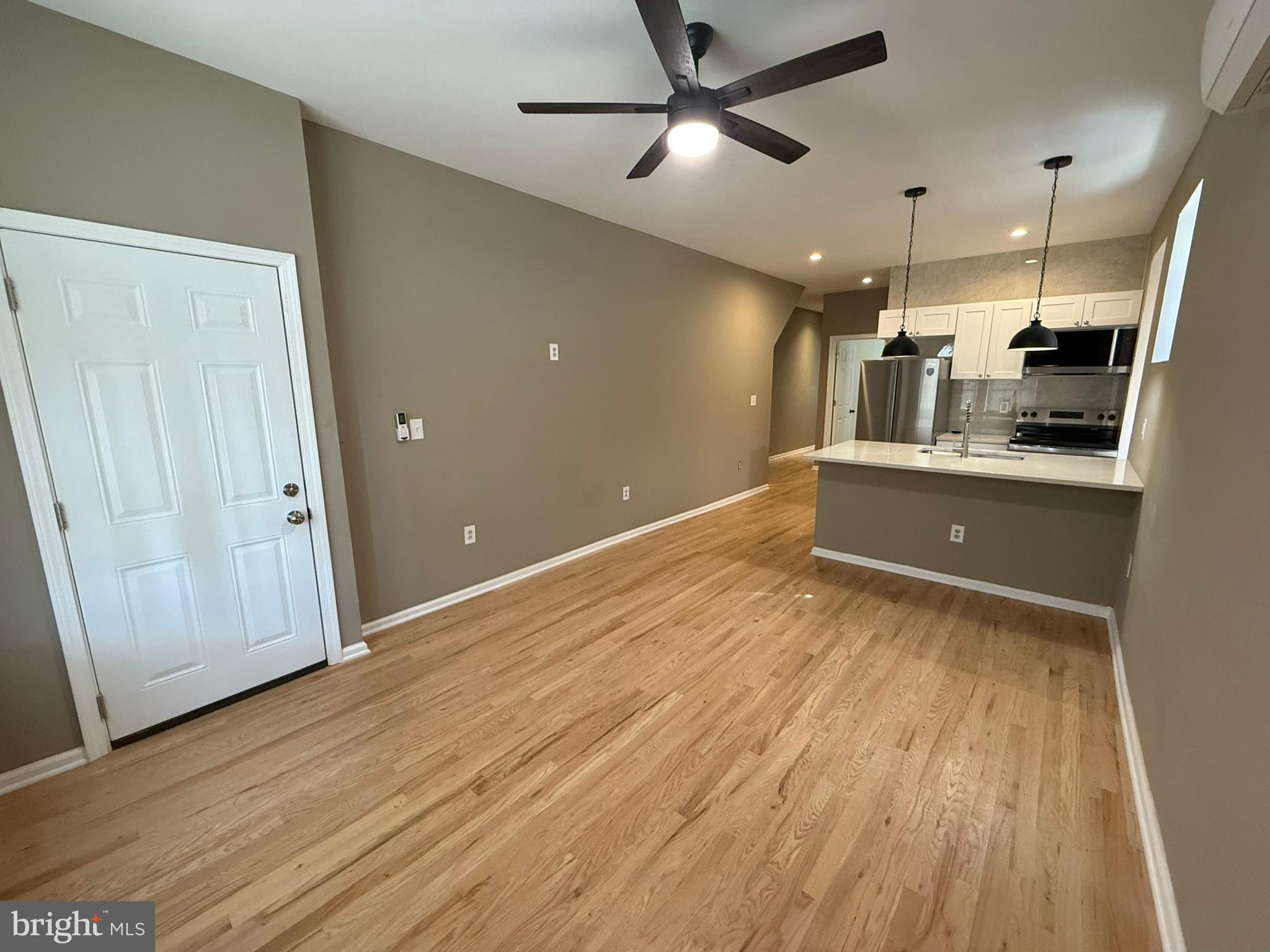 5618 Cedar Avenue, Unit 1 Philadelphia, PA 19143 - Photo 6 of 20 an empty room with wooden floor and windows