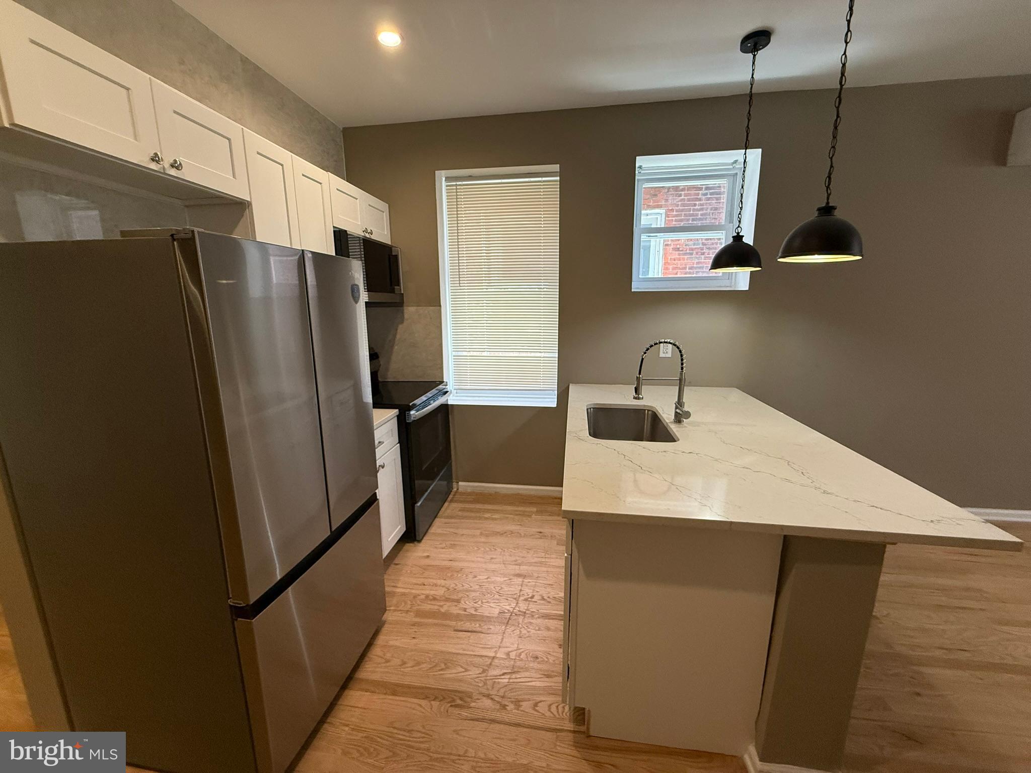 5618 Cedar Avenue, Unit 1 Philadelphia, PA 19143 - Photo 7 of 20 a kitchen with stainless steel appliances a refrigerator and a sink
