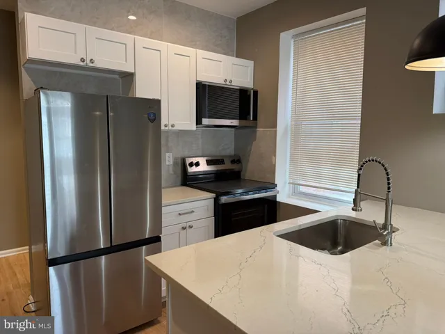 a kitchen with stainless steel appliances a refrigerator sink and microwave