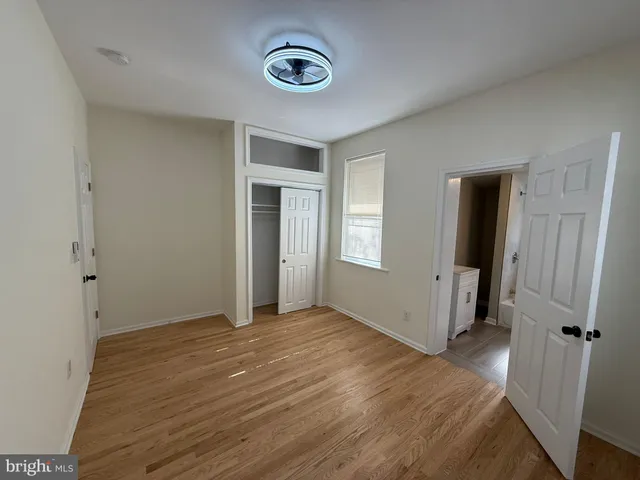 an empty room with closet and windows