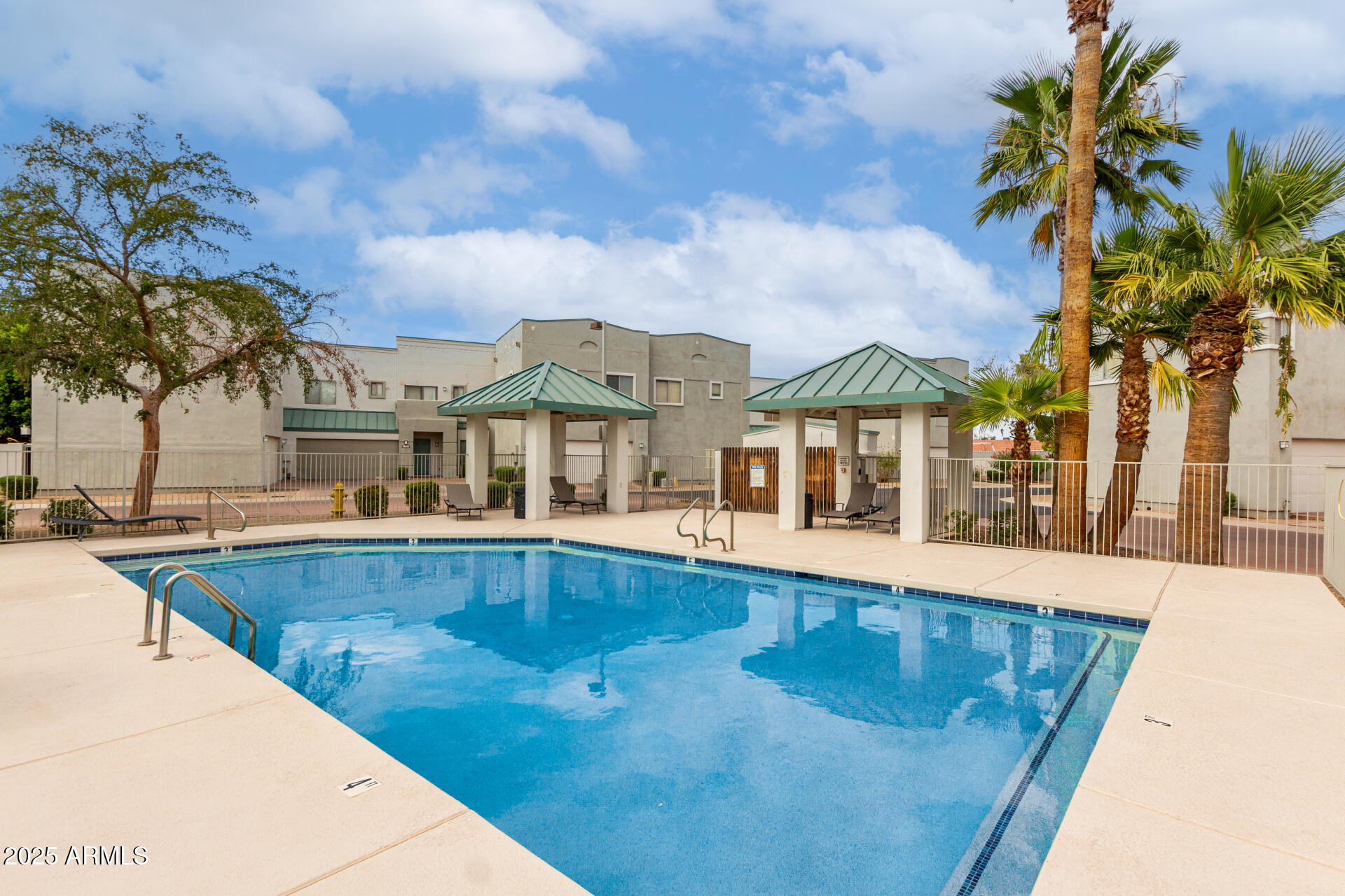 5400 South Hardy Drive, Unit 110 Tempe, AZ 85283 - Photo 29 of 31 a view of a swimming pool with a lawn chairs under palm trees