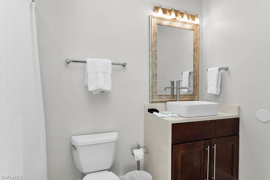 255 Columbus Way Marco Island, FL 34145 - Photo 37 of 50 a bathroom with a toilet sink and mirror