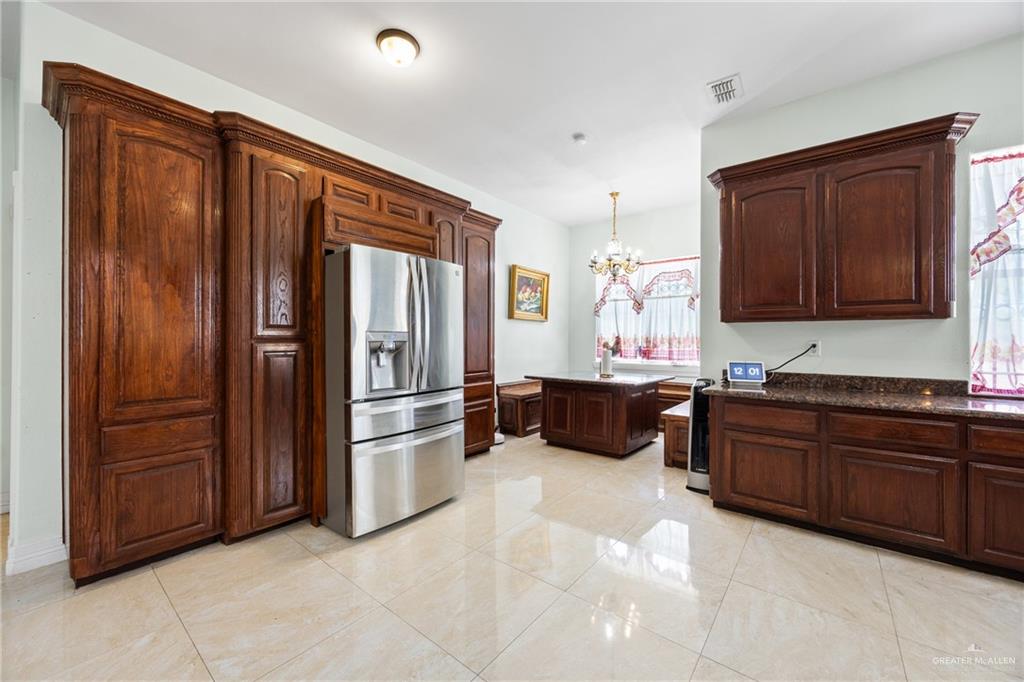 508 El Paisano Road Rio Grande City, TX 78582 - Photo 11 of 42 a kitchen with stainless steel appliances granite countertop a refrigerator and a stove
