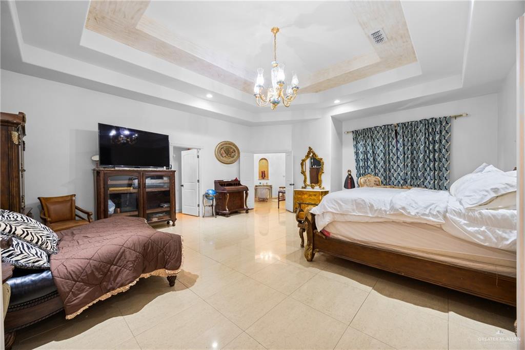 508 El Paisano Road Rio Grande City, TX 78582 - Photo 16 of 42 a spacious bedroom with a bed couch tv and a window