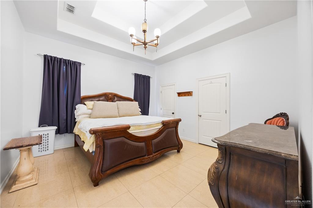 508 El Paisano Road Rio Grande City, TX 78582 - Photo 21 of 42 a bedroom with a bed and a chandelier