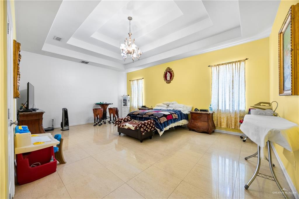 508 El Paisano Road Rio Grande City, TX 78582 - Photo 25 of 42 a bedroom with furniture and a chandelier