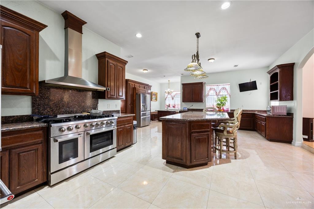 508 El Paisano Road Rio Grande City, TX 78582 - Photo 10 of 42 a kitchen with stainless steel appliances granite countertop a stove top oven a sink dishwasher a dining table and chairs