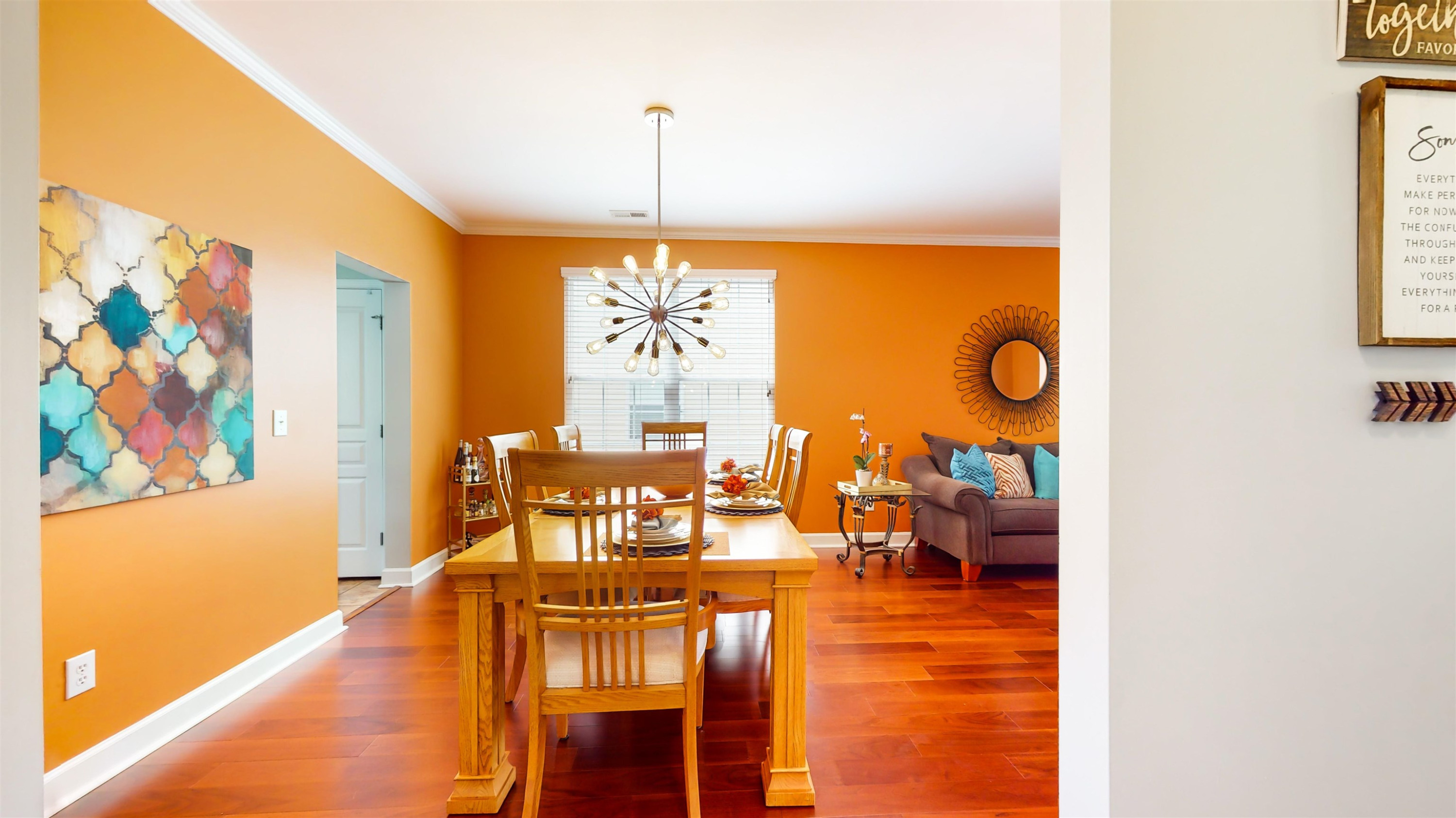 509 Ember Drive Durham, NC 27703 - Photo 5 of 24 a view of a dining room with furniture a chandelier a kitchen and wooden floor