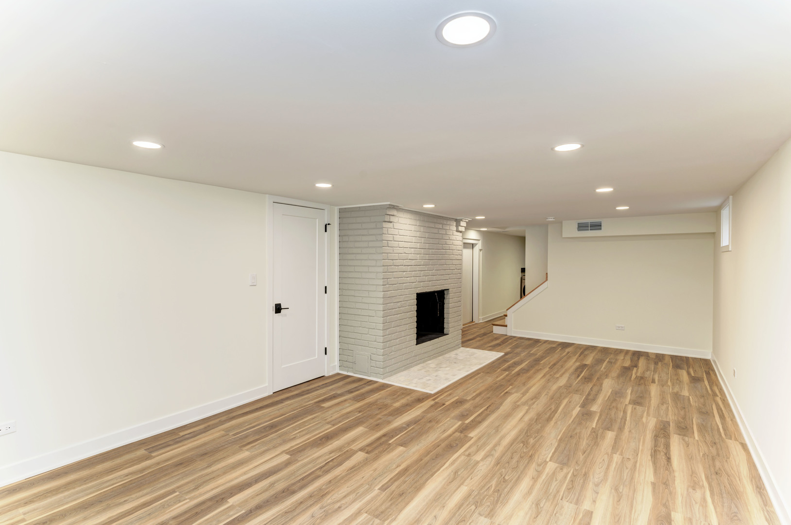 5927 Brookbank Road Downers Grove, IL 60516 - Photo 29 of 38 a view of an empty room with wooden floor and a kitchen