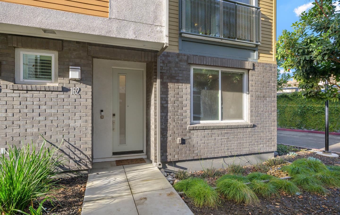 162 Nexus Loop San Jose, CA 95110 - Photo 2 of 19 a front view of a house with a garden
