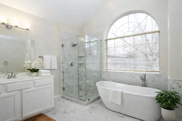 a view of an empty room with a windows and chandelier fan